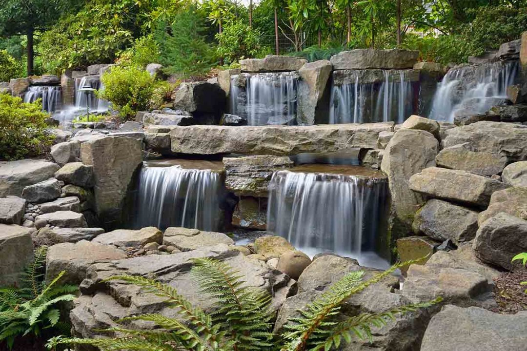Large manmade waterfall with natural boulders - 7 Dees Landscaping