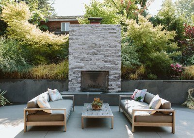 beautiful outdoor fireplace with seating by Dennis' 7 Dees