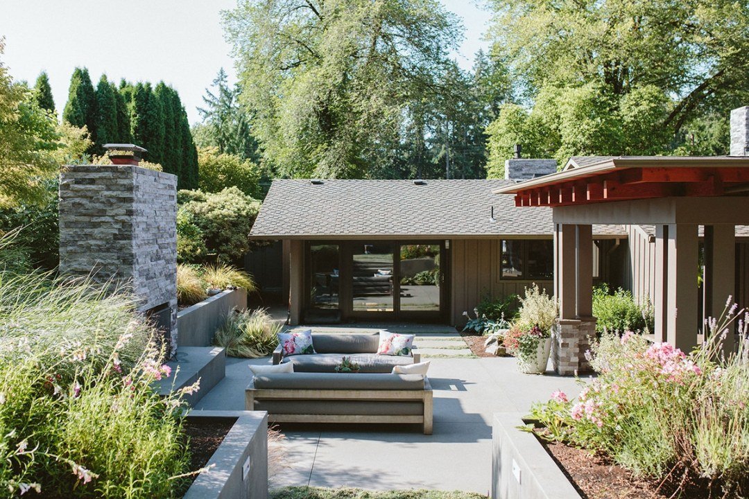 Patio with couches, planter beds, and a fireplace by 7 Dees Landscaping