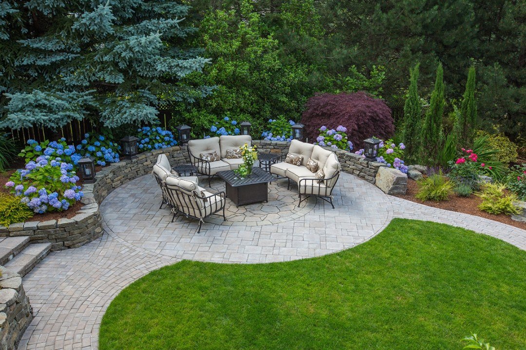 Round patio with firepit and retaining wall Jasmine vine growing vertically on a trellis - by Dennis' 7 Dees