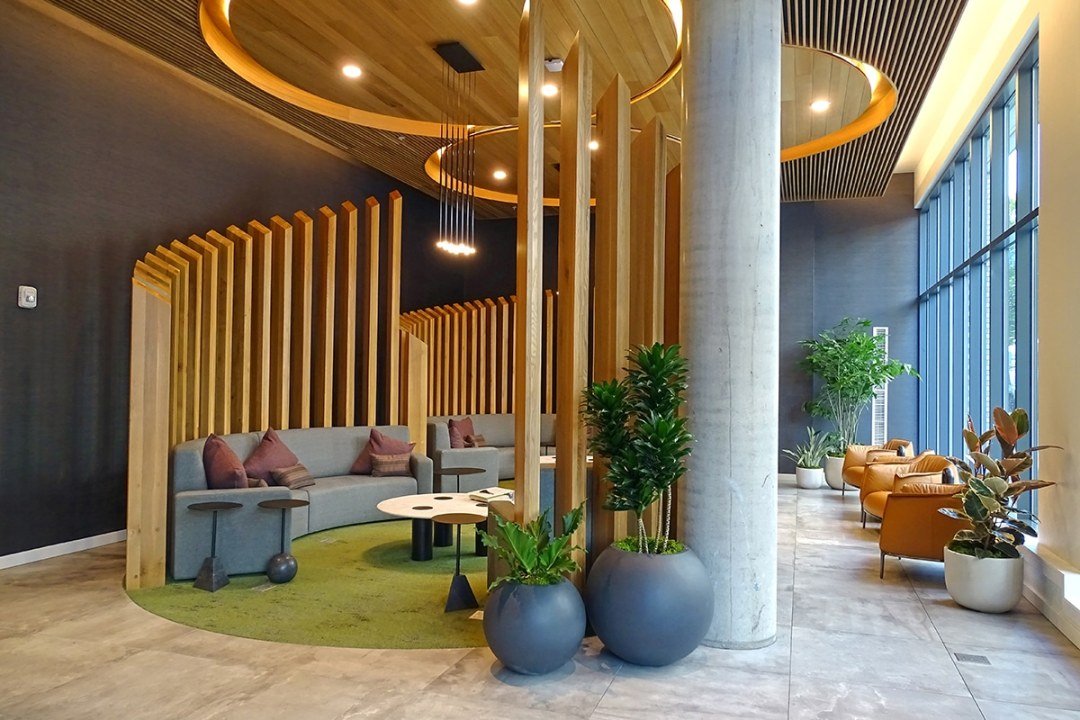 Potted plants and wooden slats create natural looking seating area in a lobby, by Urban Plantscapes