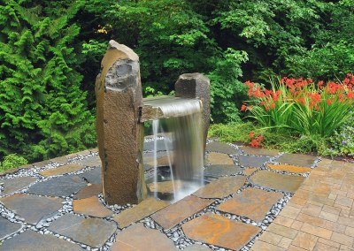Boulder water wall rain curtain water feature designed by Dennis' 7 Dees