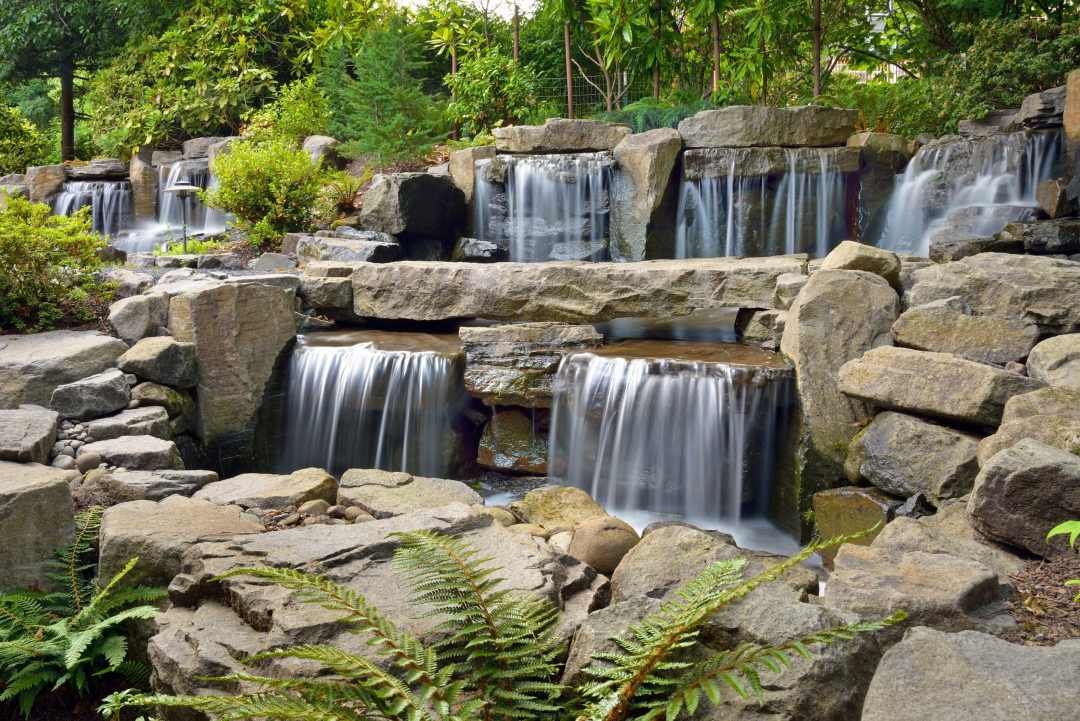 Large-scale waterfall water feature designed and installed by Dennis' 7 Dees Landscaping