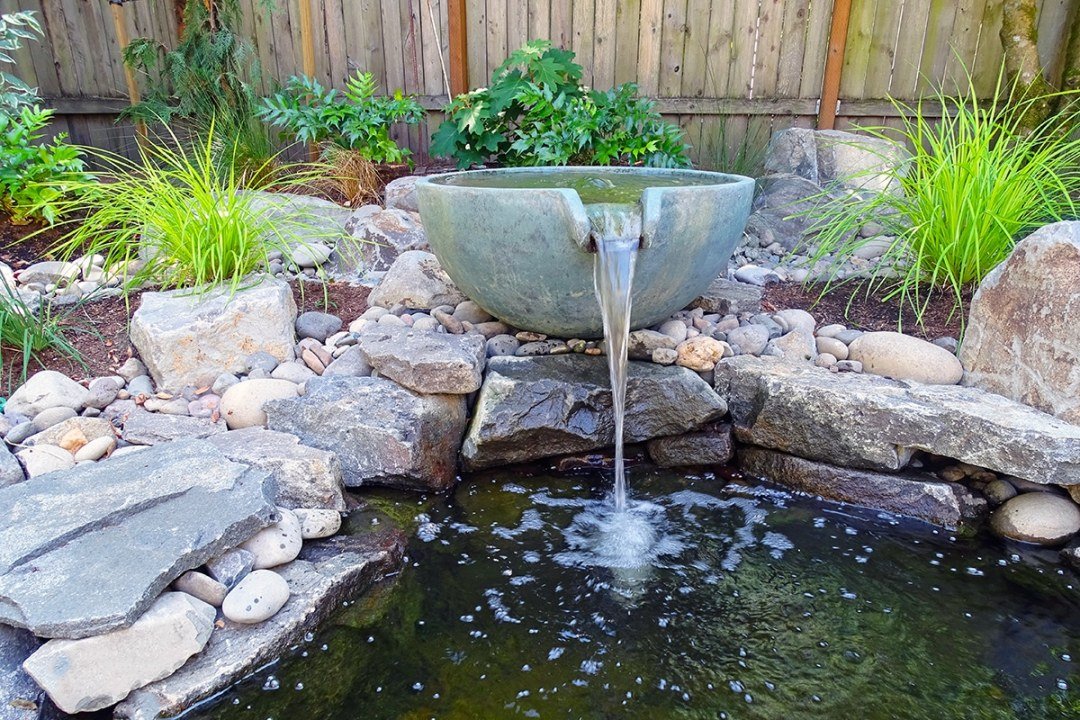 Custom pool with backyard waterfall and boulders by Dennis' 7 Dees Landscaping