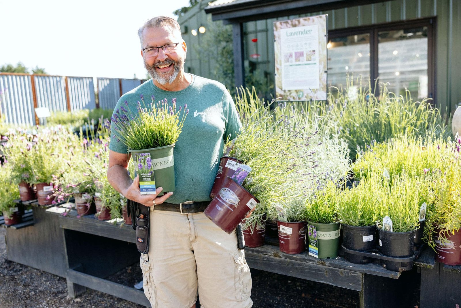 Lavender varieties held by a smiling staff member at 7 Dees Garden Center