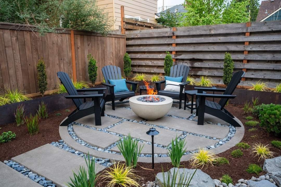 Poured pavers in a circular patio with firepit and chairs in a PNW landscape by 7 Dees Landscaping